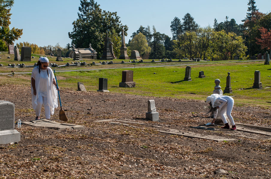 Shy Pacheco Hamilton and student sweeping the cemetery, 2017